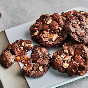 Plusieurs biscuits au chocolat, aux amandes et au caramel dans une assiette.