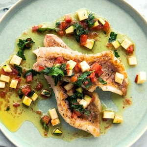 Une assiette de deux filets de poisson à la sauce vierge