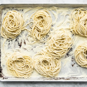 Plusieurs portions de spaghettoni sur une plaque à four.
