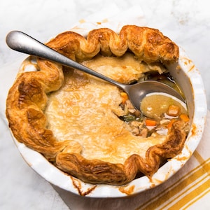 Un plat de cuisson contenant un pâté au poulet et une assiette avec une portion du pâté, vus de haut. 