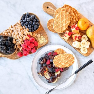 Deux plateaux remplis d'aliments pour la fondue au chocolat et une assiette remplie prête à être dégustée.