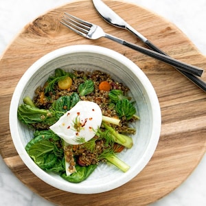 2 bols contenants des lentilles, des légumes verts et un œuf poché.