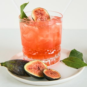 Un cocktail orangé accompagné de figues.