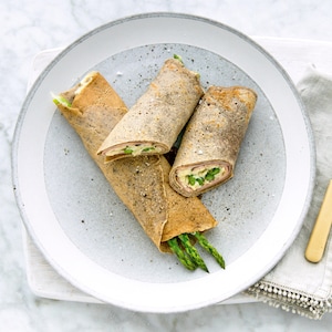 Trois roulés de crêpes dans une assiette.