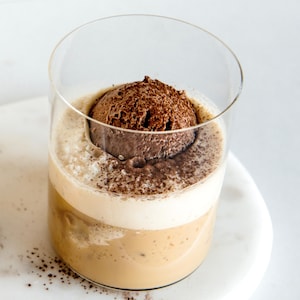 Deux verres de café avec une boule de crème glacée au chocolat dans chacun.