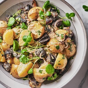 Une salade de pommes de terre et d'escargots dans une assiette.