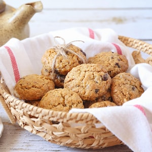 Des biscuits à la compote de pommes, aux raisins et aux noix dans un panier en osier.