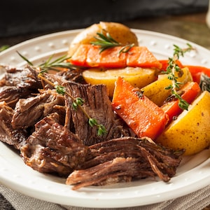 Une assiette de bœuf braisé, de pommes de terre et de carottes.