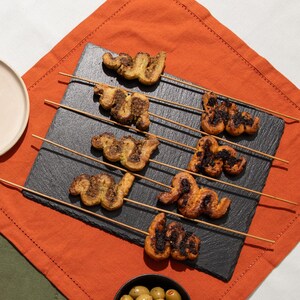 Des bouchées de pâte feuilletée de plusieurs saveurs dans une assiette.