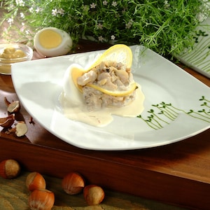Une assiette avec des buccins en salade et sauce rémoulade.