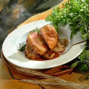 Une assiette de poitrine de canard farcie avec jus à la marjolaine.