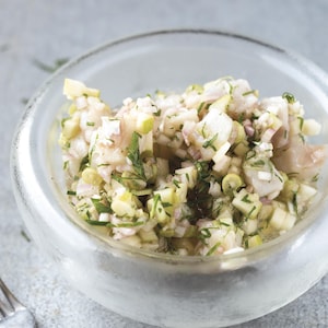 Un bol de ceviche à côté d'une fourchette.