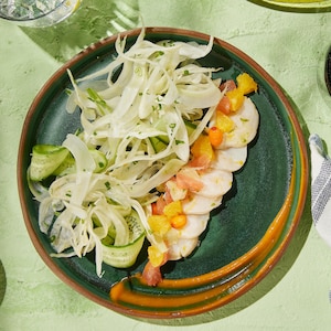 Une assiette de ceviche au pétoncle accompagné d'une salade de légumes frais.