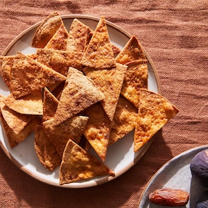 Sur une nappe, il est possible de voir une assiette contenant des chips de tortillas sucrée.