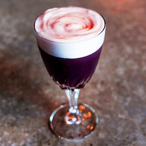 Un cocktail violet avec beaucoup de mousse.