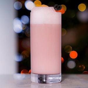 Un cocktail rose pâle dans un verre allongé.