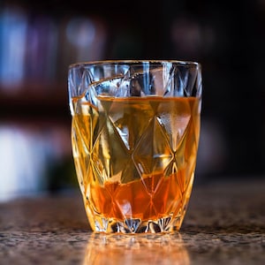 Un verre rempli d'un cocktail orangé.