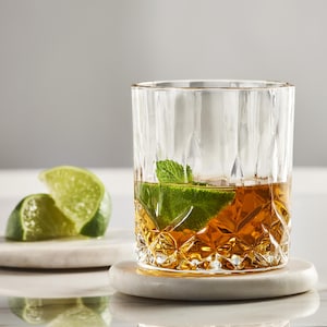 Un punch à l'érable dans un verre accompagné de quartiers de lime.