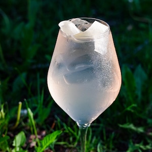 Le cocktail le spritz printanier dans un verre à vin avec des glaçons.