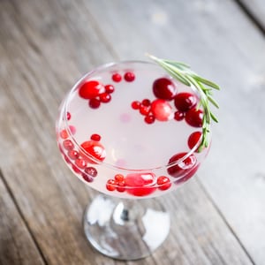 Vue en plongée sur un coupe de vodka contenant des canneberges.
