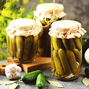 Trois bocaux remplis de cornichons à l'aneth.