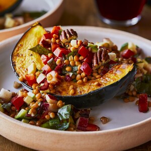 Une courge rôtie à la salade de lentilles dans une assiette.