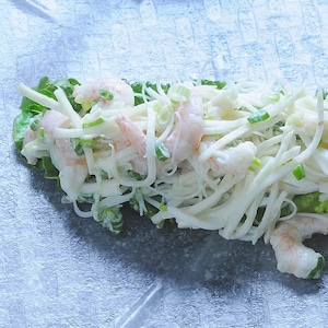 Garniture d'un rouleau aux crevettes et céleri en rémoulade sur une feuille de riz prêt à être roulé.