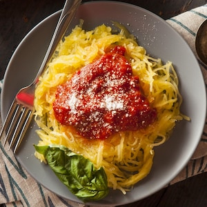 Une assiette de courge spaghetti recouverte de sauce tomate.