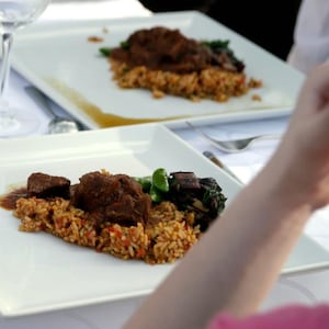 Des morceaux de viande déposés sur du riz et des légumes.