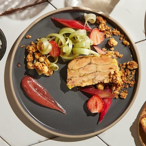 Une assiette de terrine de foie gras accompagné d'une gelée fraise et rhubarbe.