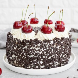 Un gâteau forêt-noire décoré de cerises et de copeaux de chocolat.