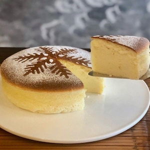 Un gâteau blanc et une forme de flocon de neige en sucre à glacer sur le dessus. 