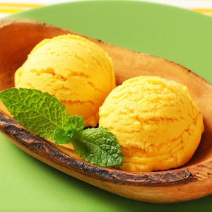 Deux boules de crème glacée à la mangue dans un bol.