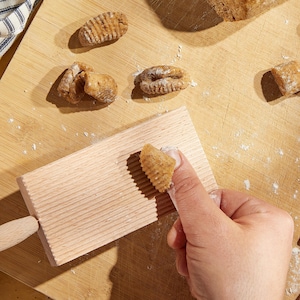 Confection de gnocchis à la main sur une planche.
