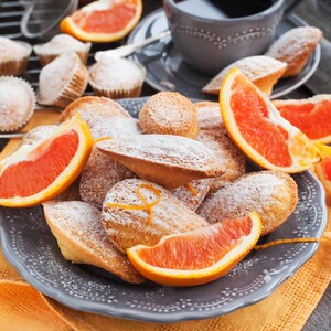 Des madeleines parfumées à l'orange dans une assiette.