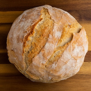 Une miche de pain à l'ancienne sur un comptoir en bois.