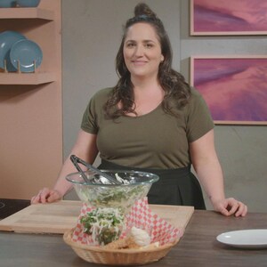 La cheffe Loounie dans une cuisine avec une salade qu'elle a cuisiné.