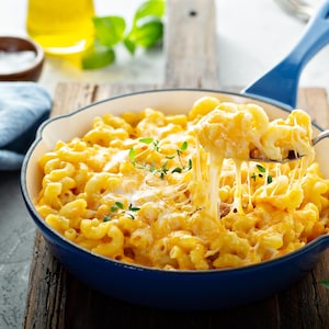 Un poêlon rempli de macaroni au fromage et aux tomates.