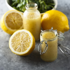 Deux petits pots de marinade au citron entourés de citrons.