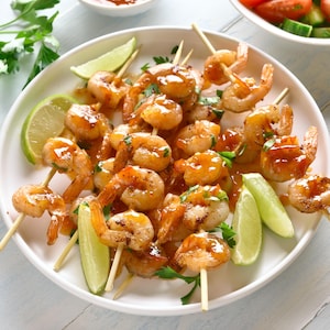 Plusieurs brochettes de crevettes recouvertes de marinade mexicaine.