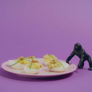 Une assiette d'oeufs mimosa garnis de ciboulette et d'olives.