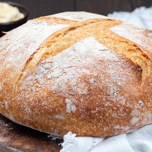 Une miche de pain au levain naturel sur une planche à découper.