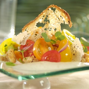 Panzanella aux tomates cerises mélangées sur une assiette.