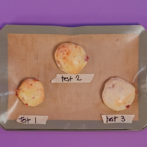 Trois spécimens de pizzas pochettes sur une plaque tapissée de papier de cuisson.