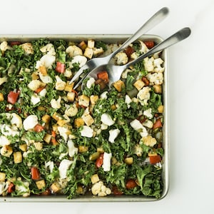 Une plaque de cuisson garnie de poivrons, de cubes de tofu et de chou kale vue de haut.