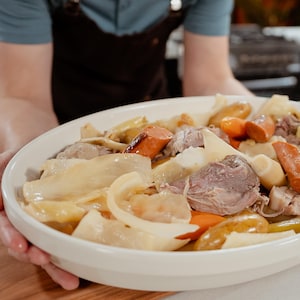 Un plat de service rempli de porc demi-sel et de légumes d'hiver.