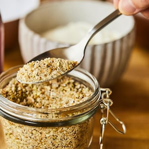 Mélange de grains entiers concassés dans un pot vitré.