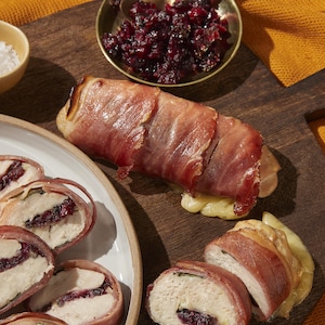 Une poitrine de poulet farcie au prosciutto sur une planche à découper.