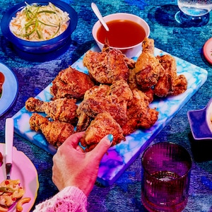 Un plat au centre de la table rempli de poulet frit. 