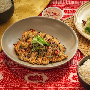 Une escalope de poulet panée servie avec des bok choys et du riz.